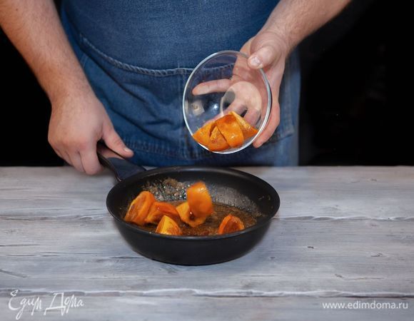 Хурму нарежьте крупными дольками, добавьте в сковороду, жарьте 1 минуту.
