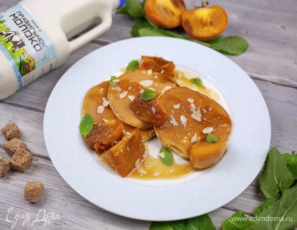Выложите на тарелку готовые оладьи с обжаренной хурмой. Подавайте, украсив мятой.