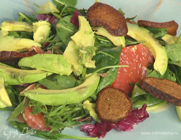 На тарелку выложить салат. Сверху положить авокадо и крутоны.  