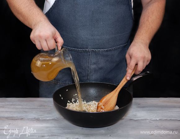 Постоянно перемешивая, частями добавьте в рис теплый бульон и готовьте на среднем огне около 10–12 минут. После закипания чуть посолите, поперчите.