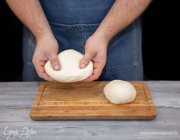 Поднявшееся тесто разделите на две части: побольше и поменьше. Раскатайте каждую часть.