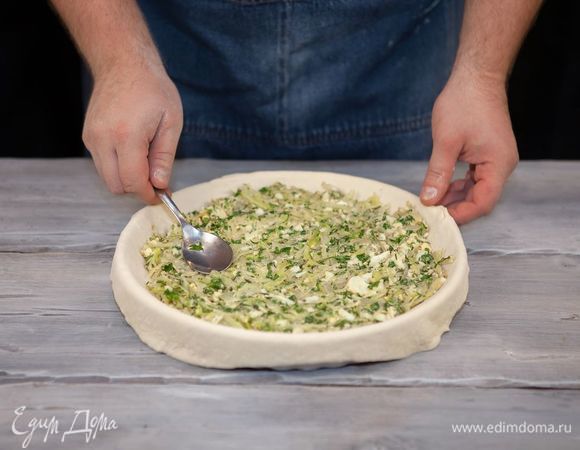 На противень, смазанный маслом, положите большую часть теста, накрыв бортики. Выложите начинку, сверху накройте оставшимся тестом, скрепив края.