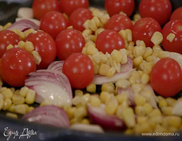 На разогретую сковороду-гриль выложить дольки лука, помидоры-черри, кукурузу, зубчики чеснока и обжаривать до появления румяных полосок.