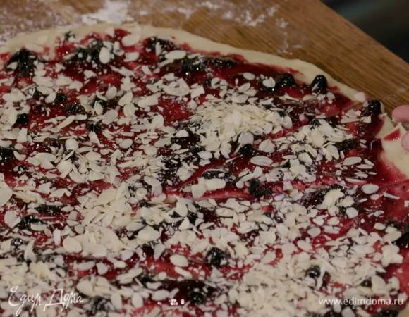 Смазать тесто джемом, посыпать миндальной стружкой и тонким, острым ножом нарезать на равные треугольники-сектора, а затем сделать рогалики, сворачивая тесто от широкой стороны к узкой.