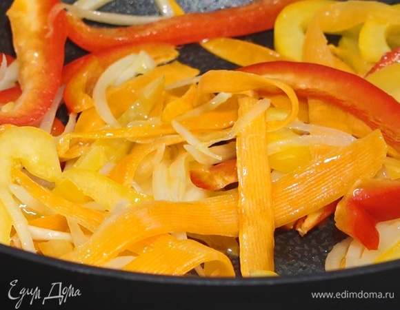 Положить лук, перемешать, продолжить обжаривать. Чеснок раздавить плоской стороной ножа и целиком добавить в сковороду.