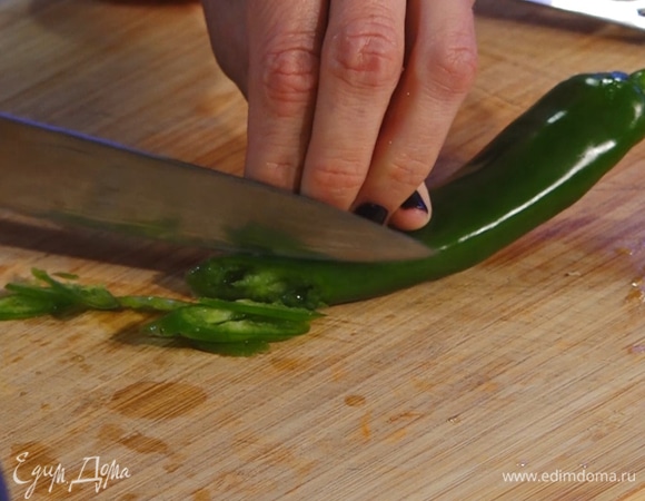 Мелко нарезать зеленый перец чили, убрать семена. Чили и сладкую паприку добавить в сковороду.
