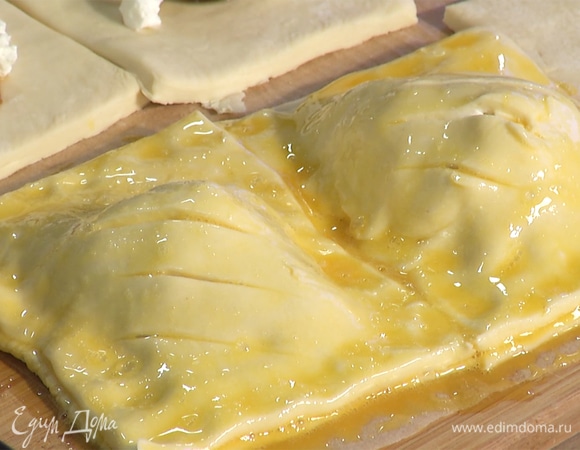 Две слойки накрыть сверху квадратами теста. Скрепить края, сверху сделать ножом насечки и смазать яичной смесью.