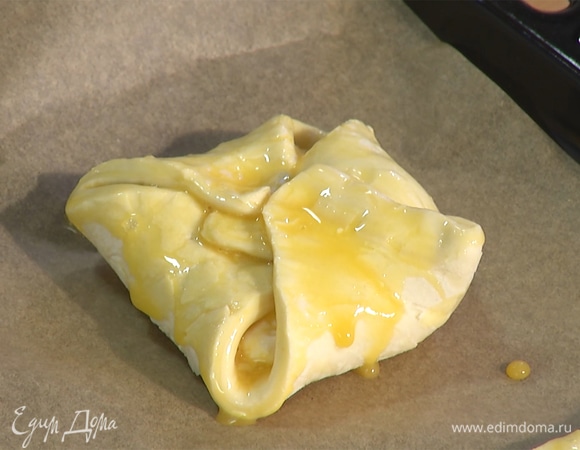 Две слойки сложить в форме конверта — уголки завернуть к центру и соединить. Сверху промазать яичной смесью.