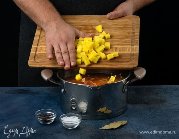 Нарежьте куриное филе небольшими кубиками, выложите в кастрюлю.