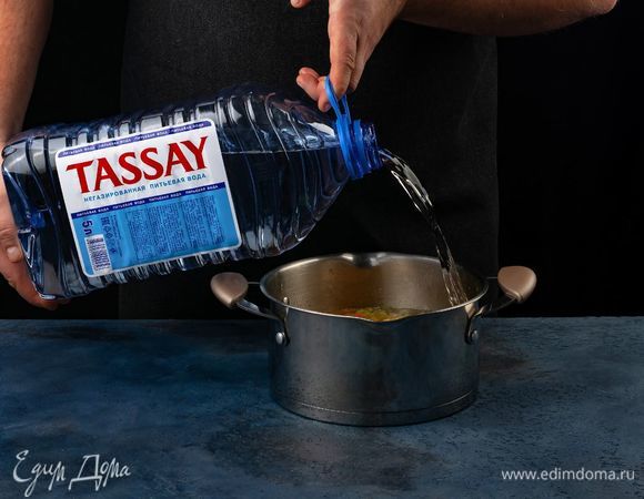 Залейте водой Tassay. Добавьте в кастрюлю фасоль и тертые помидоры.