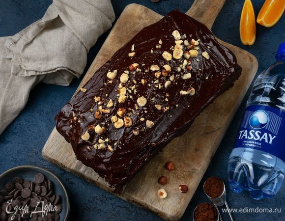 Чуть остывший кекс полейте глазурью, посыпьте орехами и поставьте в холодильник для застывания.