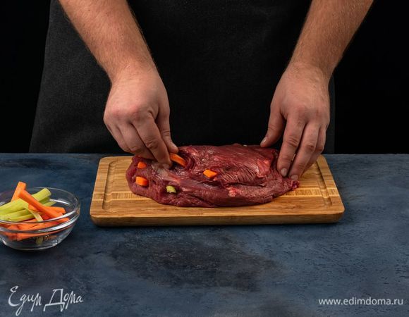 Нарежьте дольками морковь. Мясо нашпигуйте нарезанными морковью и сельдереем.
