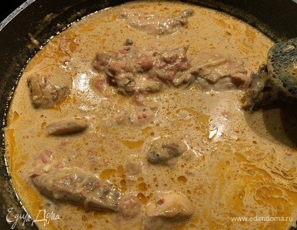 Курицу разделываем на кусочки и выкладываем в сковороду, немного раздвигая соус. Через 5 минут вливаем сверху кокосовое молоко, добавляем соль и перец. Все тщательно перемешиваем и накрываем крышкой. Тушим примерно 30 минут до получения густой массы.