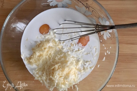 Смешать сливки и молоко, добавить яйца, тертый сыр и дольку чеснока.