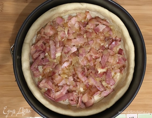 Достать корж из духовки, выложить грудинку с луком.