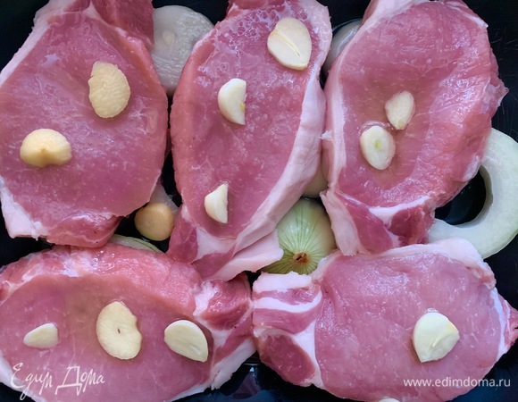 Духовка разогревается до 190°C. Лук очистить, нарезать кольцами, форму смазать маслом. Кладу лук, сверху — мясо, нарезаный чеснок, соль, перец.