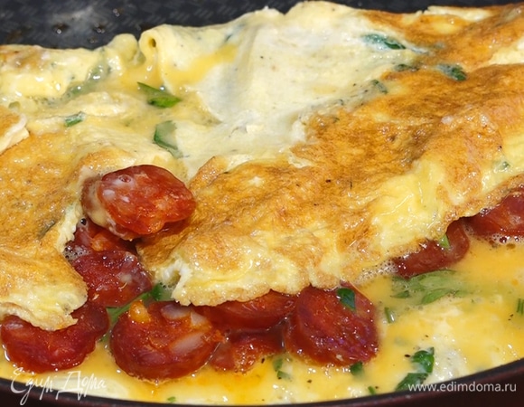 Выложить чоризо на одну сторону омлета, сверху накрыть второй половиной. Довести до готовности. 