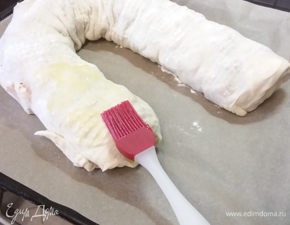 Выложить штрудель на противень швом вниз. Пирог большой, поместился на противень в виде подковы. Щедро смазать растопленным сливочным маслом. Выпекать в заранее разогретой до 200°C духовке около 50 минут. Если штрудель начнет подгорать, накрыть фольгой или пергаментной бумагой.