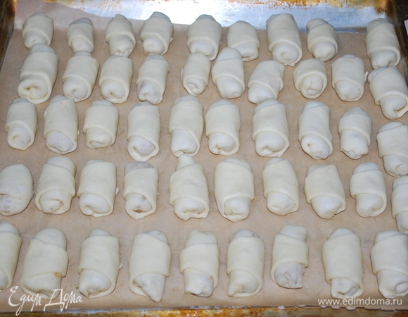 Положите на противень рулетики хвостиками вниз, чтобы при выпечке они не поднимались. Выпекайте при температуре 180°C примерно 20 минут до готовности.