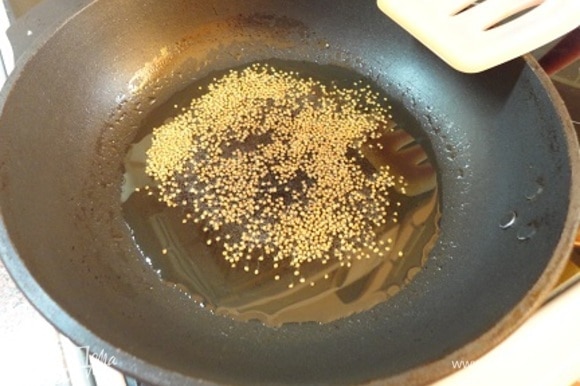 Масло разогреть, выложить семена горчицы и прогреть их до того момента, когда они начнут трескаться.