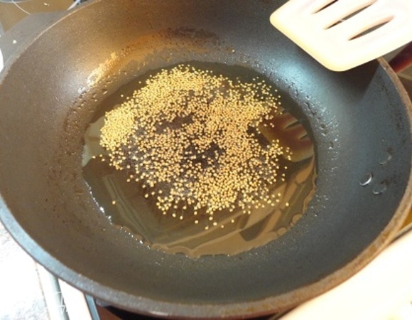 Масло разогреть, выложить семена горчицы и прогреть их до того момента, когда они начнут трескаться.