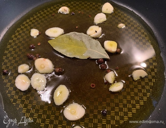 В сковородку — оливковое масло, нарезанный чеснок, перец, лавровый лист. Пару минут прожариваю.