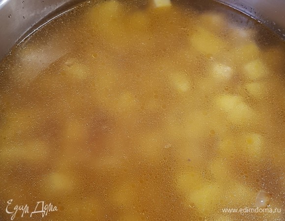 Картофель почистить и нарезать кубиками. Выложить в бульон картофель, лук и морковь. Посолить по вкусу и варить до готовности овощей.