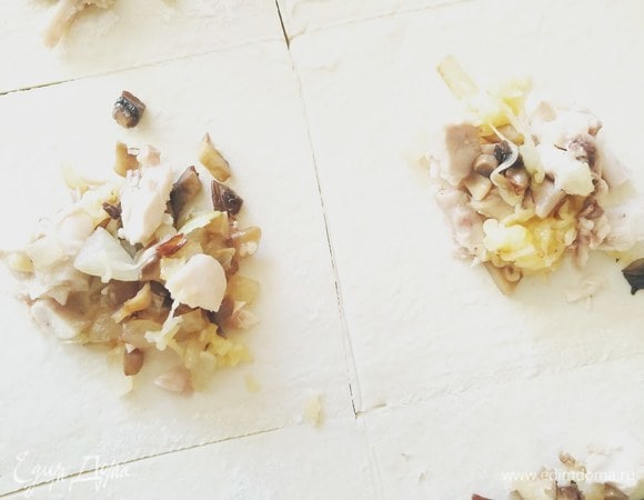 Слоеное тесто нарезаем на квадраты и в центр каждого кладем немного начинки.