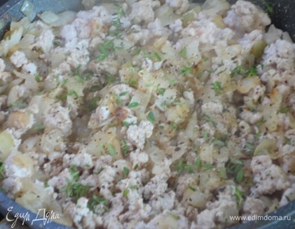 Начинаем с начинки. Лук (3 шт., примерно 300 г) нарезать мелкими кубиками и обжарить на 2 ст. л. растительного масла до золотистого цвета. Добавить фарш, интенсивно помешивая и не давая мясу собираться в кусочки. Посолить, поперчить, добавить листочки тимьяна или 1 ч. л. сухого. Перемешать и тушить под крышкой на медленном огне 10 минут.