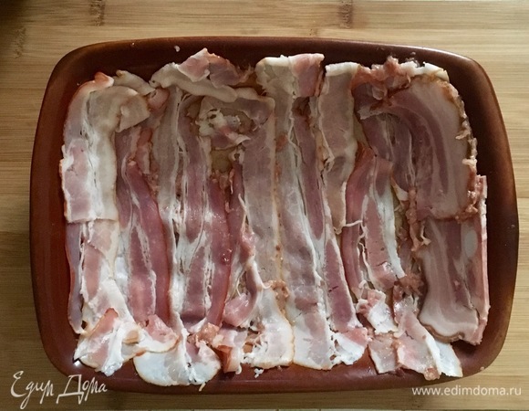 Грудинку нарезать тонкими длинными полосками. Треть полосок отложить, остальные уложить поперечными рядами в прямоугольную форму для запекания так, чтобы дно и бока были закрыты.