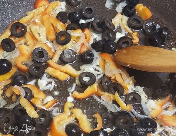 К луку с перцем добавить чеснок и все тушить примерно 1 минуту. Потом добавить маслины и все еще тушить 5 минут.