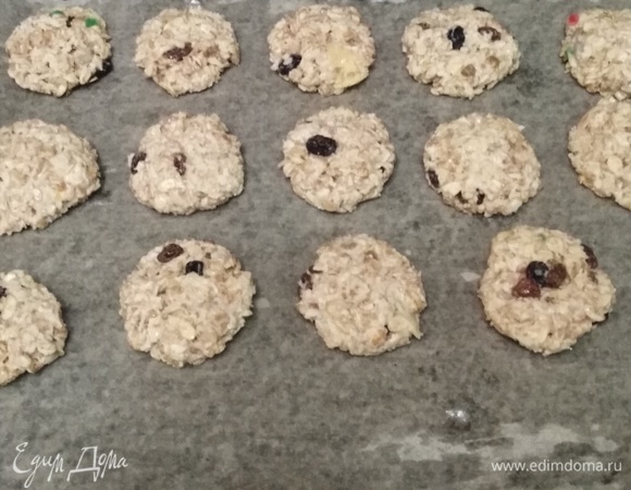 Противень застелить пекарской бумагой. Смазать растительным маслом. Из теста сформировать шарики. Приплюснуть. Выложить на противень. Разогреть духовку.