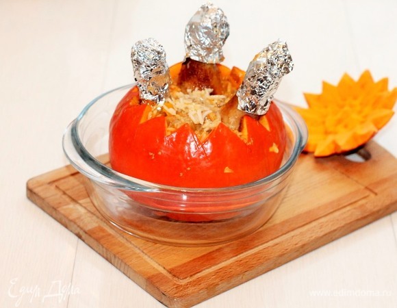 Помещаем тыкву в формочку для запекания и заполняем рисовым гарниром. Заливаем сверху соусом. Закрываем тыкву «крышкой» (верхней частью тыквы). Ставим формочку в разогретую до 180°C духовку и запекаем до готовности на протяжении около 45 минут.