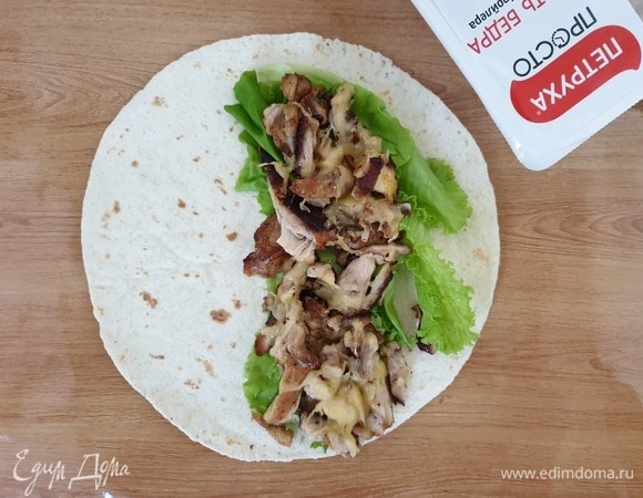 Можно собирать наше блюдо. На тортилью выкладываем листья салата, затем курицу с сыром.