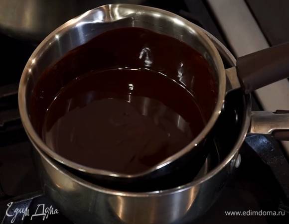 Шоколад поломать небольшими кусочками и вместе со 100 г предварительно размягченного сливочного масла растопить на водяной бане, затем слегка остудить.