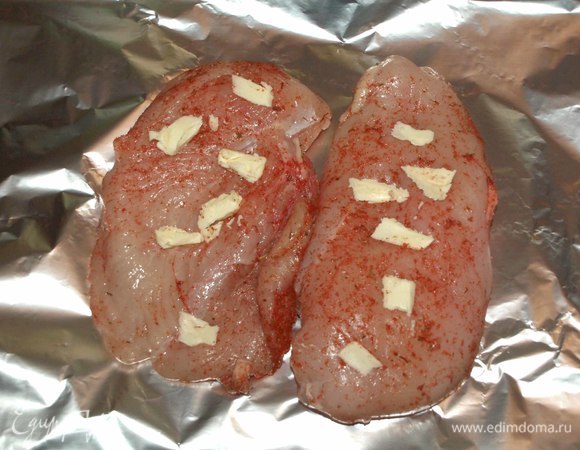 На куриное филе кладем сливочное масло. Заворачиваем филе в фольгу. Кладем в форму для запекания и отправляем на 30–40 минут в заранее разогретую до 180ºС духовку.