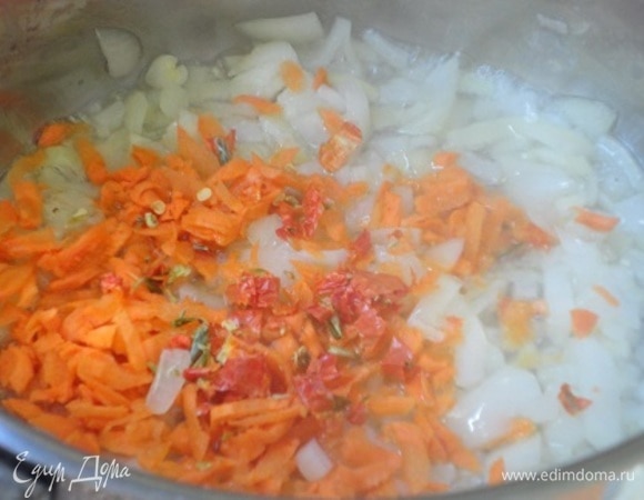 Пассеруем лук, чеснок, морковь и хлопья острого красного перца прямо в кастрюле с толстым дном, добавив растительное масло.