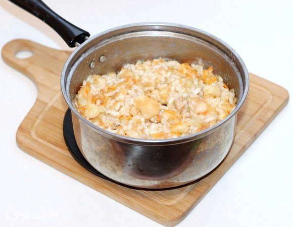 Выкладываем лук с морковью в кастрюлю с отваренным рисом. Добавляем 1 ст. л. соевого соуса, сливочное масло, мякоть яблок, бульон или воду. Перемешиваем. Вместо соли — соевый соус.