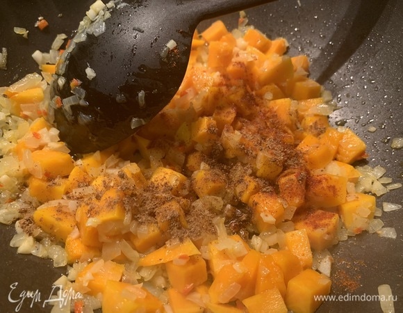 У тыквы срезаем корочку, мякоть режем небольшими кубиками. Отправляем в сковороду к луку с чесноком. Сверху посыпаем паприкой и гарам масала. Тушим на медленном огне до тех пор, пока тыква не станет мягкой, 5–10 минут.