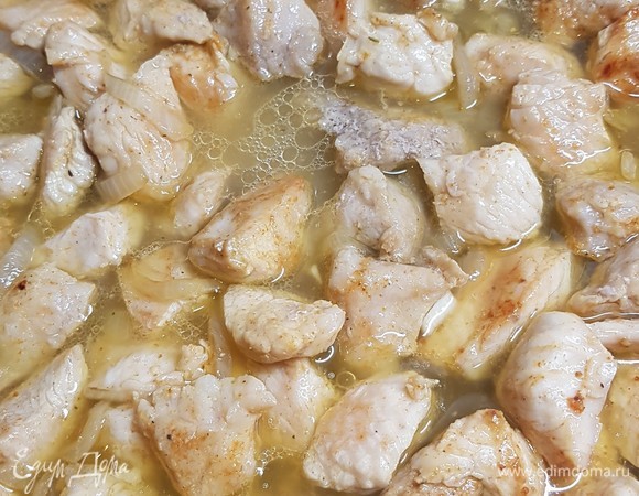 Вернуть индейку к луку. Добавить мелко нарезанный чеснок. Влить воду. Довести все до кипения и убавить огонь до самого маленького. Посолить и поперчить по вкусу. Тушить примерно 40 минут.