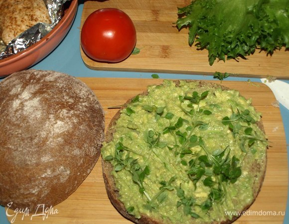 Одну половинку хлеба смазываем пастой из авокадо. Посыпаем зеленым базиликом.