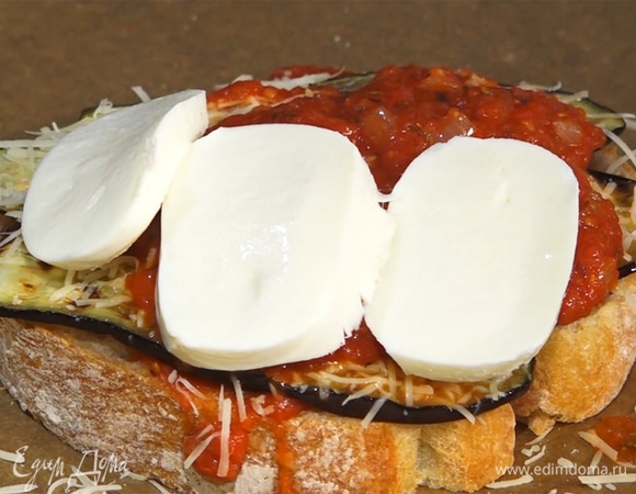 На хлеб выложить слоями ингредиенты: томатный соус, баклажаны, пармезан, снова соус и моцареллу.