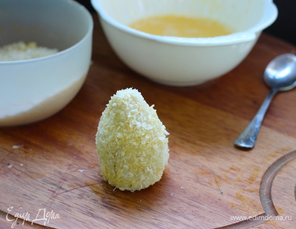 Нагрейте растительное масло в небольшой кастрюле до температуры 180°C. Окуните крокеты во взбитые яйца, а затем в панировочные сухари.