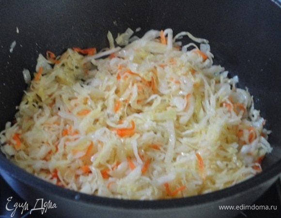 Добавить отжатую капусту и тушить на медленном огне 10 минут. Рассол не выливать.