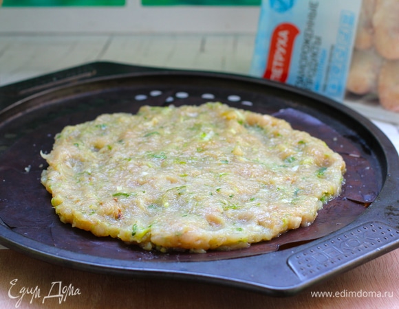 Противень застелить пергаментной бумагой, выложить на нее массу и разровнять ложкой, придавая круглую форму пиццы. Получается очень большая пицца.