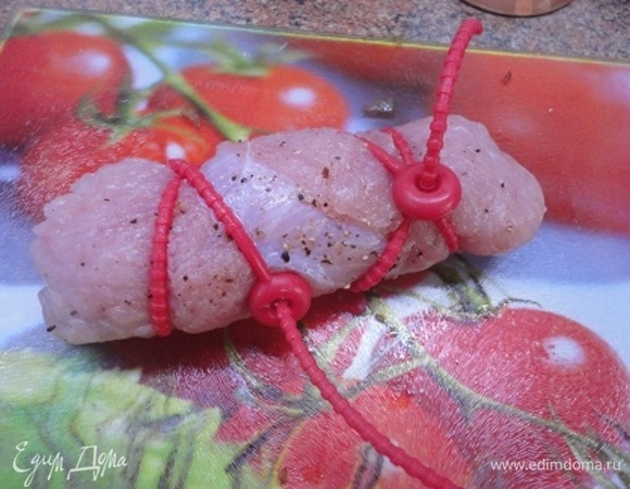 Сверните мясо в рулет, закрепите, смажьте маслом.