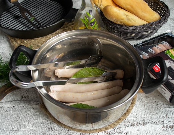 В кастрюлю наливаем 1 литр кипятка, насыпаем чайную ложку соли, добавляем лавровые листики. В кипящую воду кладем колбаски на 2–3 минуты. Сливаем воду, сбрызгиваем колбасу оливковым маслом.