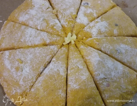 Тесто выложить на пергамент, посыпанный мукой, распластать руками в круг, посыпать сверху так же, небольшим количеством муки, и разрезать ножом на сегменты. Нож тоже желательно припылить мукой, чтобы тесто за ним не тянулось.