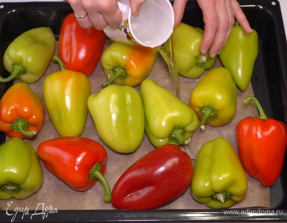 Обычно я использую разноцветные перцы, чтобы салат получился красивее и аппетитнее. Мою перцы и выкладываю на противень. Наливаю немного воды, чтобы перцы не пригорали, и отправляю в разогретую до 200°C духовку на 20 минут.