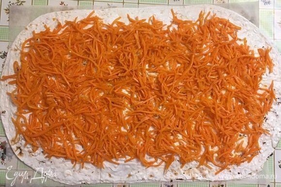 Второй лаваш смазываем соусом и распределяем морковь по поверхности. Затем смазываем третий лаваш соусом и накрываем этой стороной морковь.